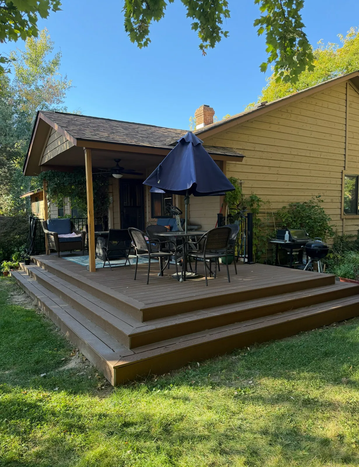 Composite deck replacement with wraparound steps down to the lawn in Boise, Idaho, built by Kemsley Construction