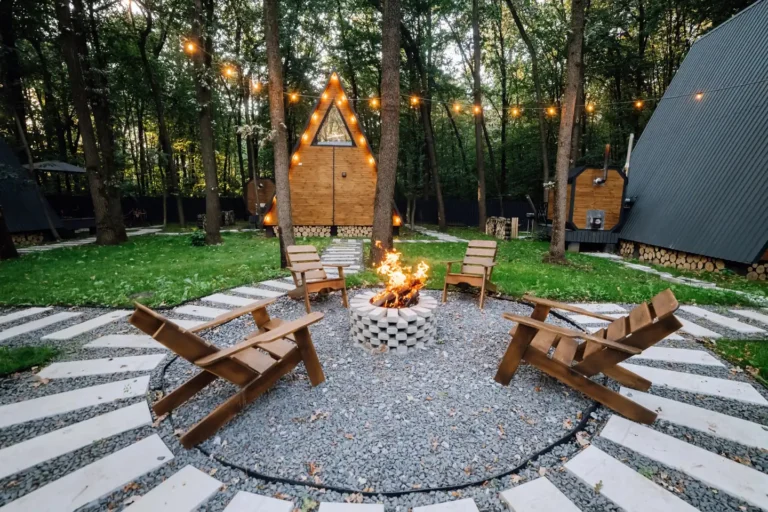 Backyard fire pit with Adirondack chairs and a gravel and paver seating circle under string lights, fire pits in Boise, Idaho