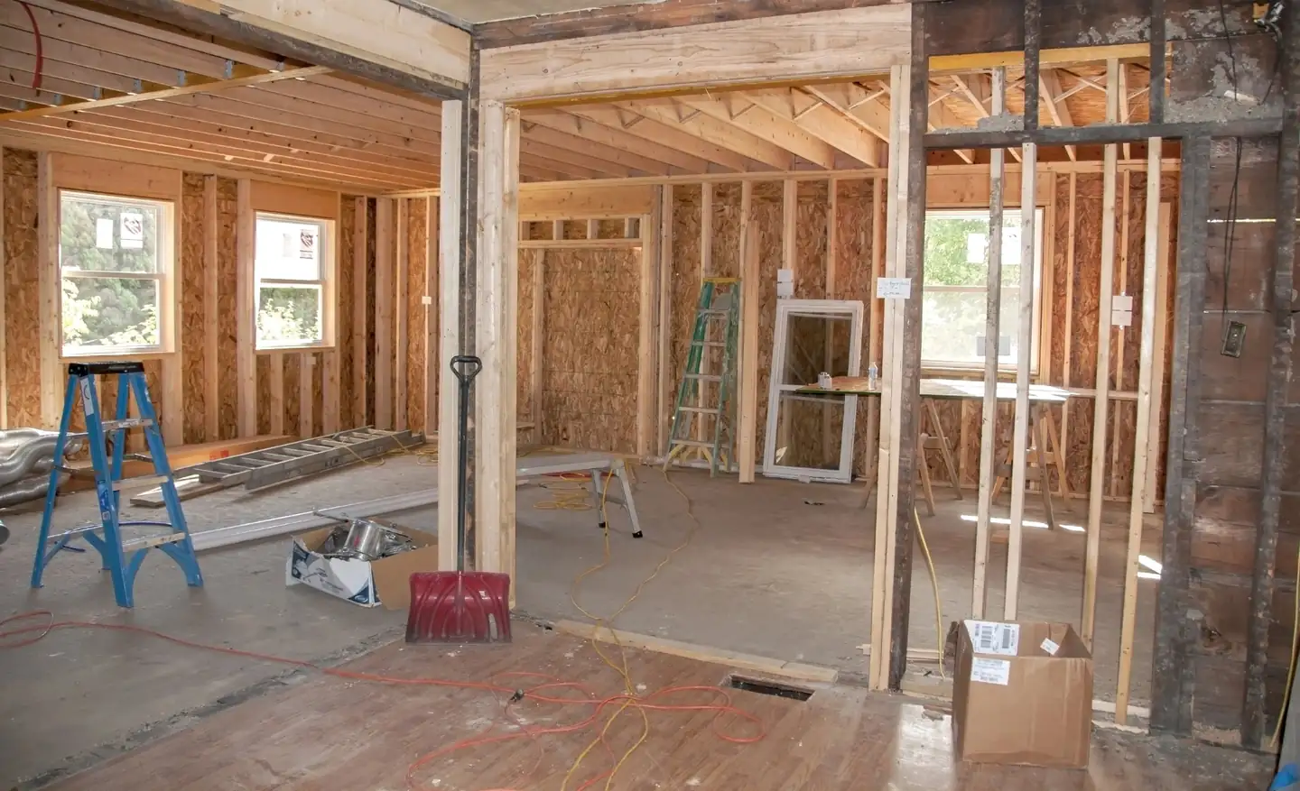 Home addition under construction with new wood framing, windows and roof trusses tied into the existing house, home additions in Boise, Idaho