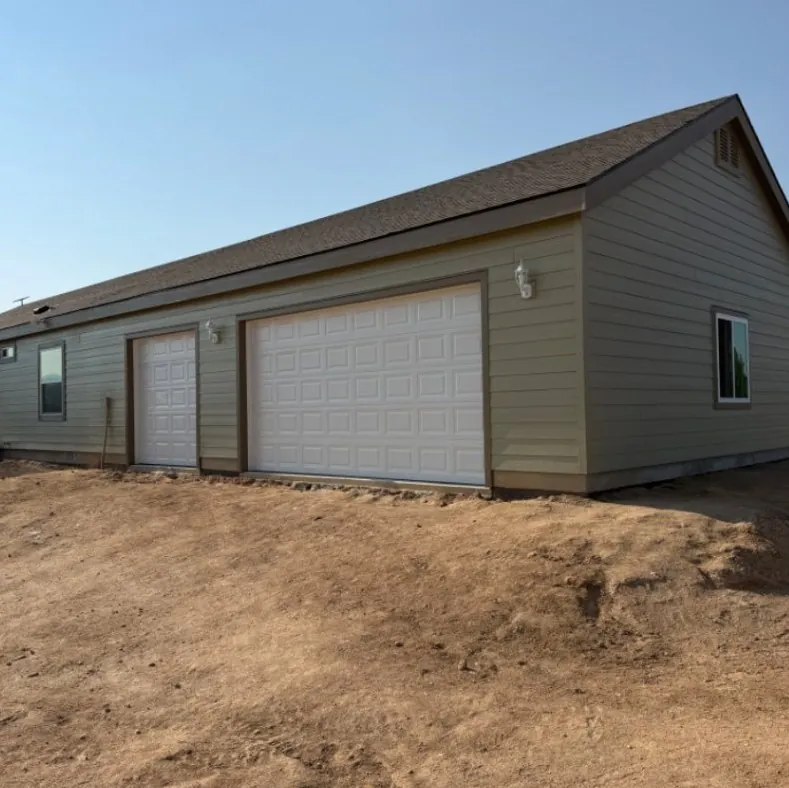 Three-car attached garage with siding matched to the home near Mountain Home, Idaho, built by Kemsley Construction