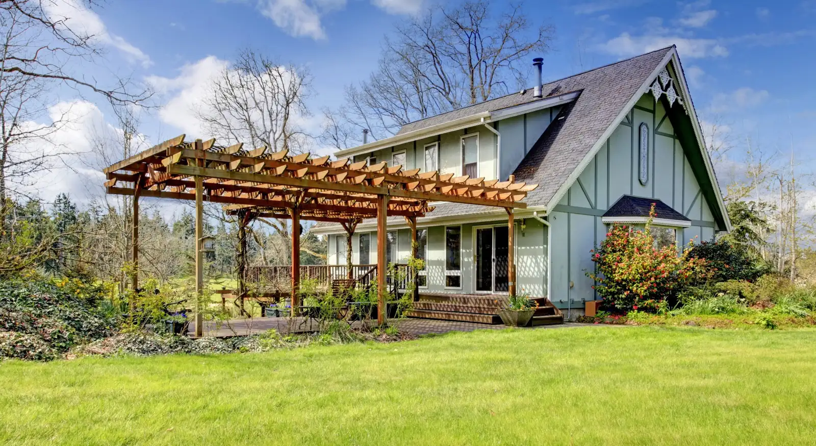 Large wood pergola with timber posts and rafters over a backyard deck beside a home, custom pergolas in Boise, Idaho